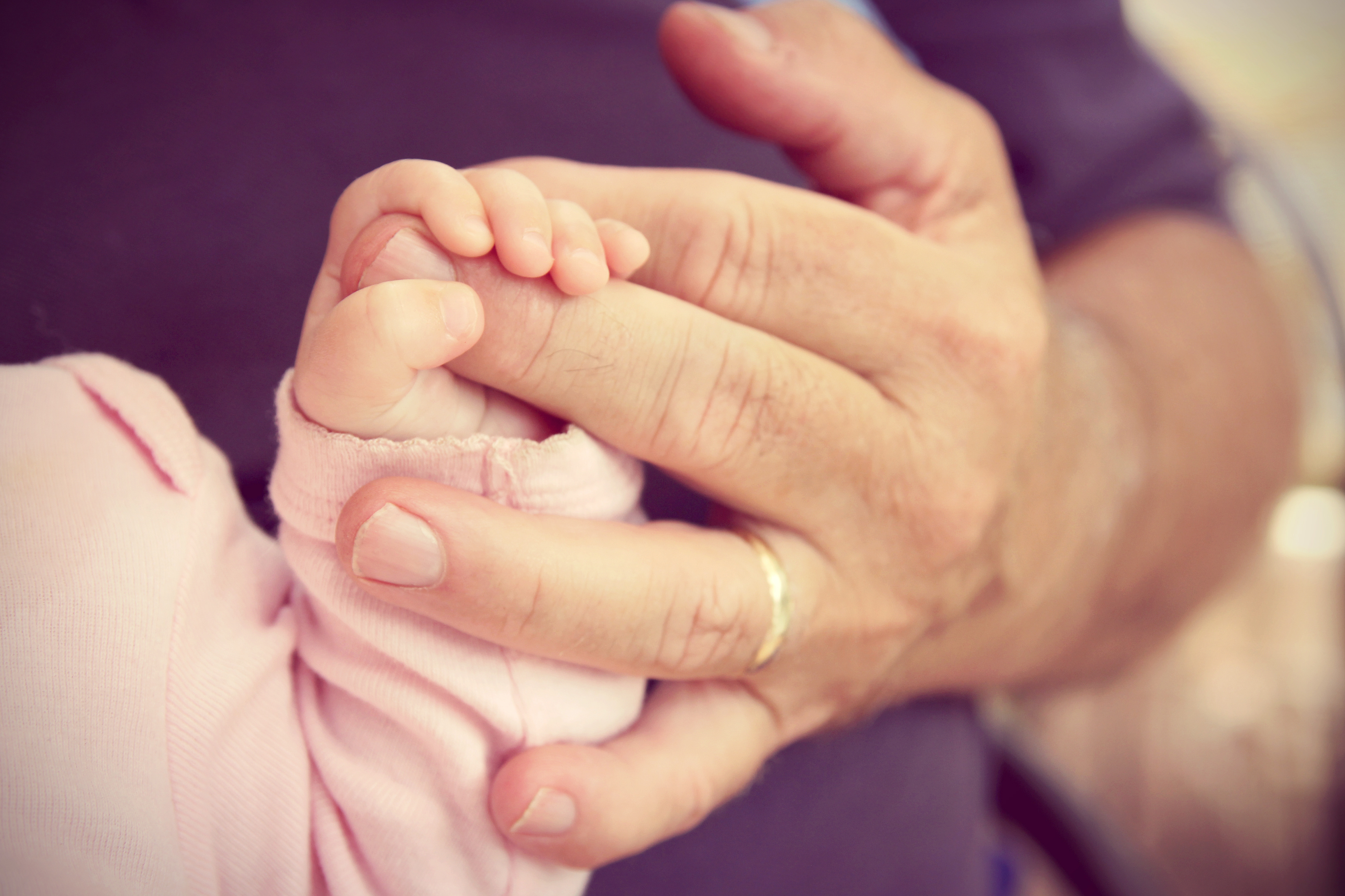 Newborn Baby Girl Holding Grandpa's Hand