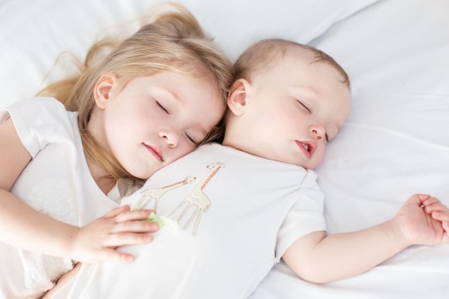 Girl and baby sleeping together