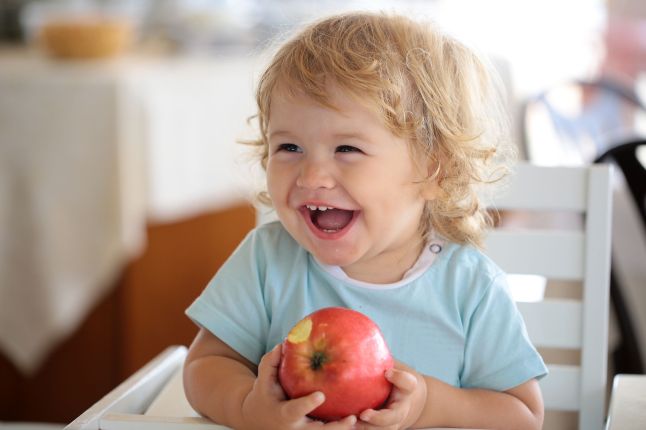 Laughing kids eating apple
